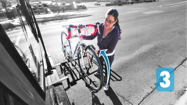 Cyclist hooking support arm on front wheel of bicycle